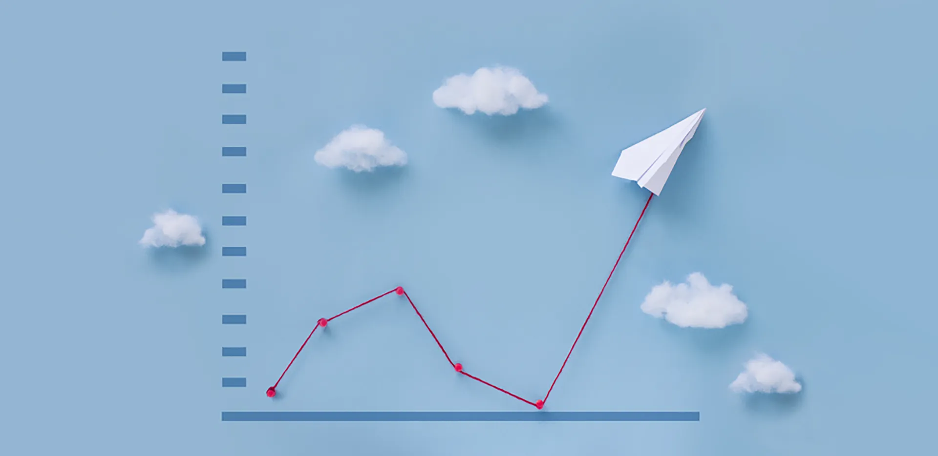 A line graph with a paper plane and cotton ball clouds. The line is red yarn.