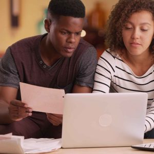 couple pays their bills on their laptop