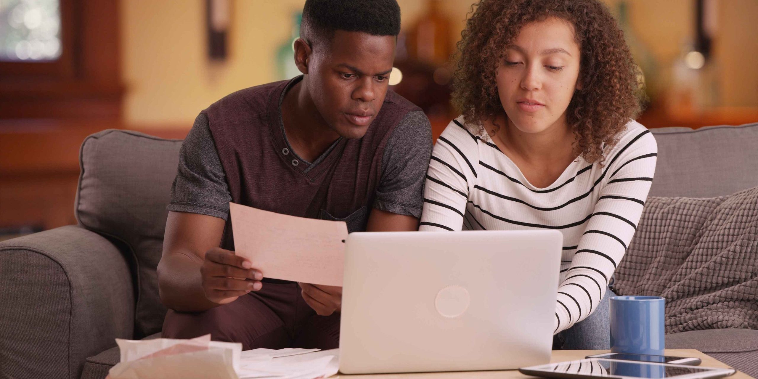 couple pays their bills on their laptop