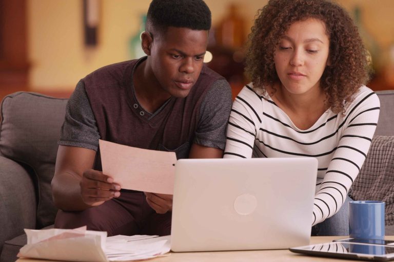 couple pays their bills on their laptop