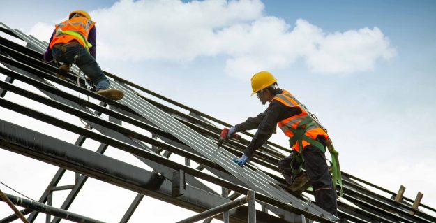 worker wear safety height equipment to install the roof. Fall arrestor device for worker with hooks for safety body harness, Worker as in the construction site