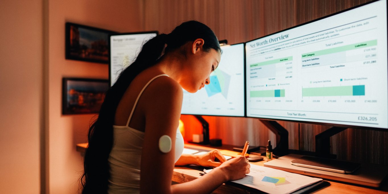 Woman is wearing small sensor on the back of upper arm for measuring glucose levels due to diabetes.