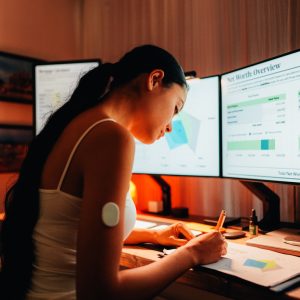 Woman is wearing small sensor on the back of upper arm for measuring glucose levels due to diabetes.