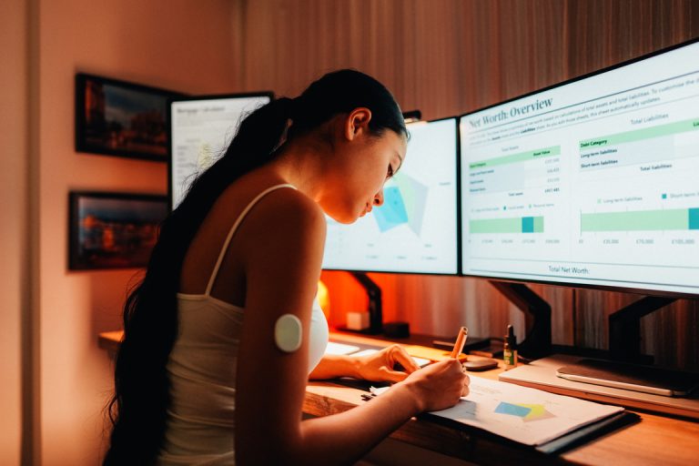 Woman is wearing small sensor on the back of upper arm for measuring glucose levels due to diabetes.