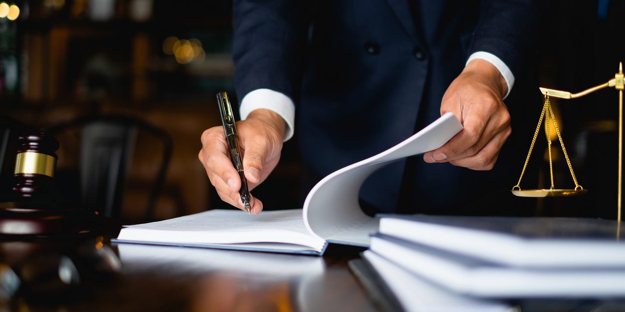 Close up lawyer businessman working or reading lawbook in office workplace for consultant lawyer concept.